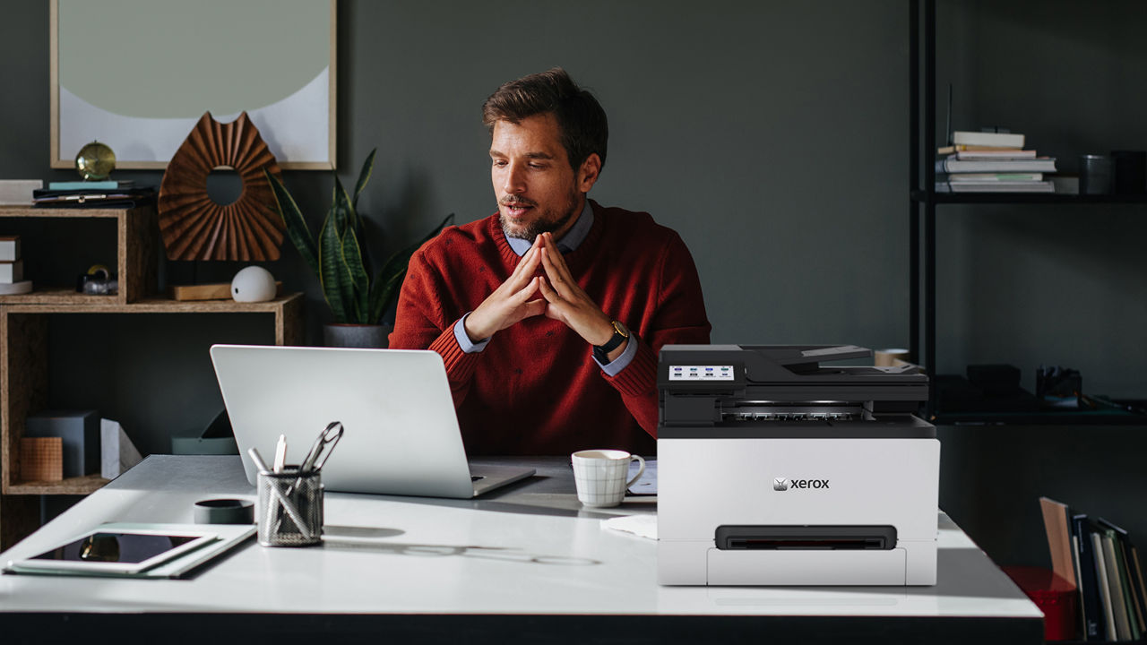 A Xerox 305 MFP printer on a home desk office with person working