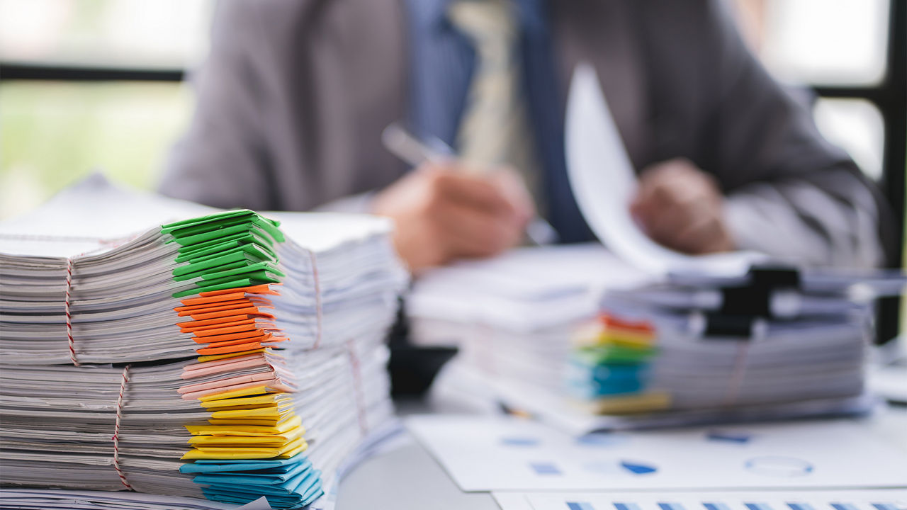 a person checking documents records on the table