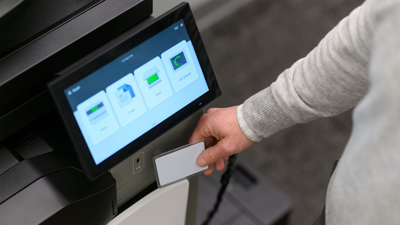 person using ID badge to access printer