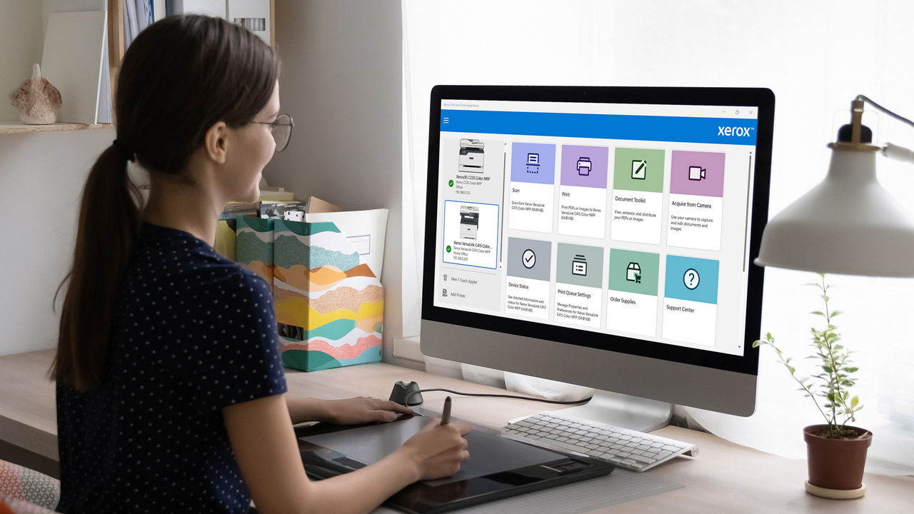 A young professional using a computer showing the Xerox print scan experience application
